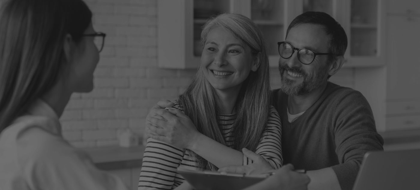 Man and woman sitting across desk from woman