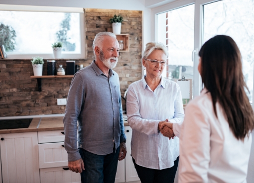 Senior woman shaking hands with woman next to her husband