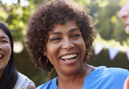 Woman laughing outdoors with two friends