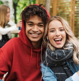 Teenage boy and girl smiling together outdoors