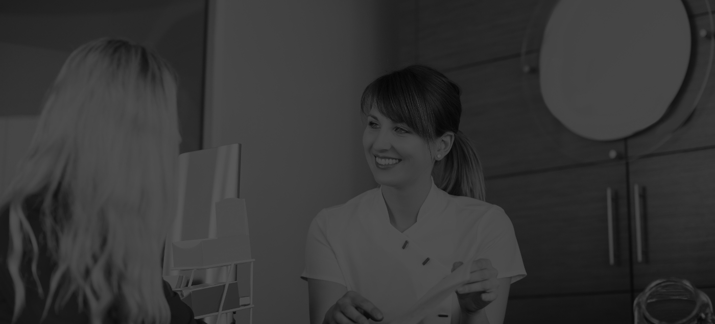 Dental receptionist talking to a patient