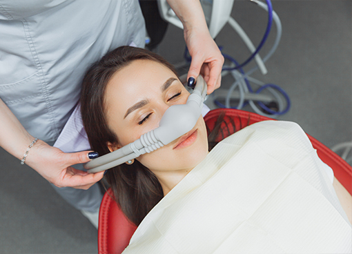 Woman in dental chair wearing nitrous oxide mask